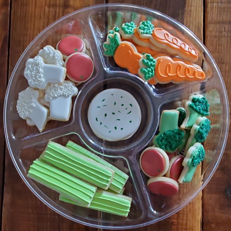 a plastic tray filled with lots of different types of cookies and candies on top of a wooden table