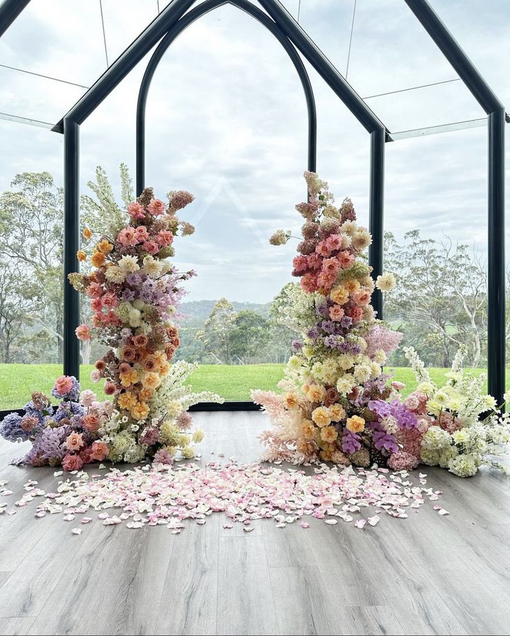 an arch made out of flowers on top of a wooden floor