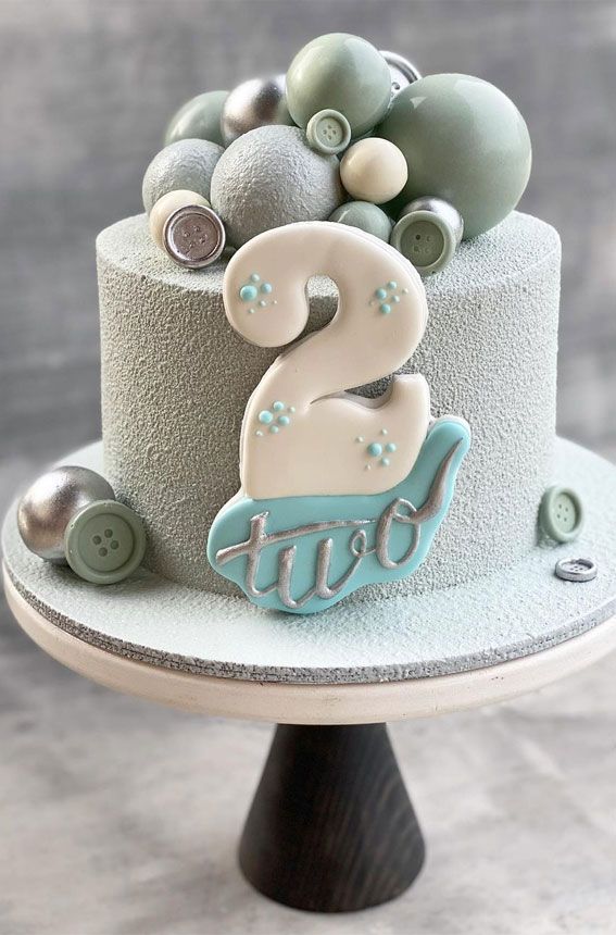 there is a cake with buttons on it and the number two in the top tier