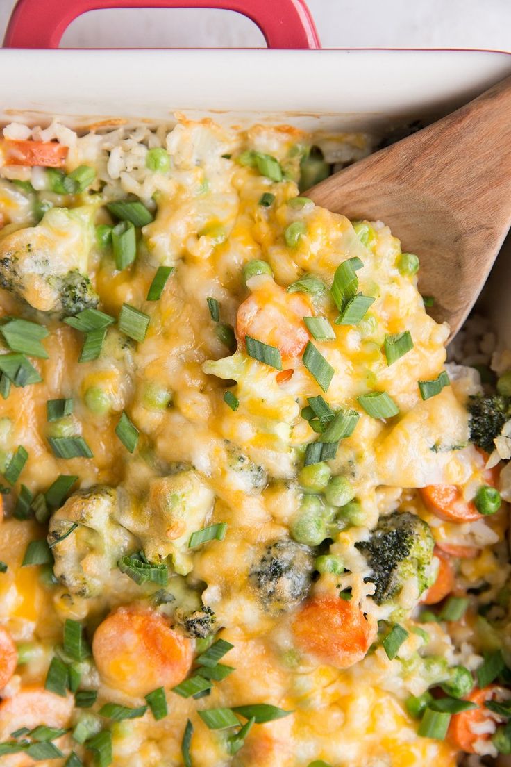 a casserole dish with broccoli, carrots and rice