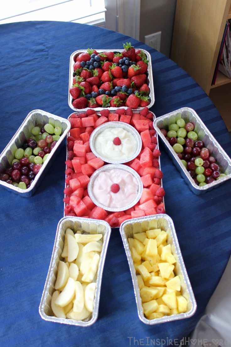 an arrangement of fruit arranged in the shape of a man's face on a table