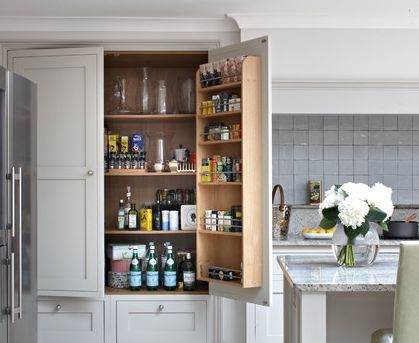 an open cabinet in the middle of a kitchen