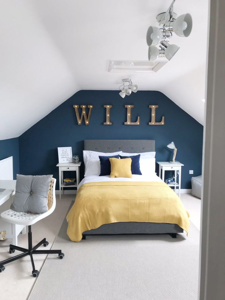 a bedroom with blue walls and white carpeted flooring, along with a bed that has a yellow comforter on it