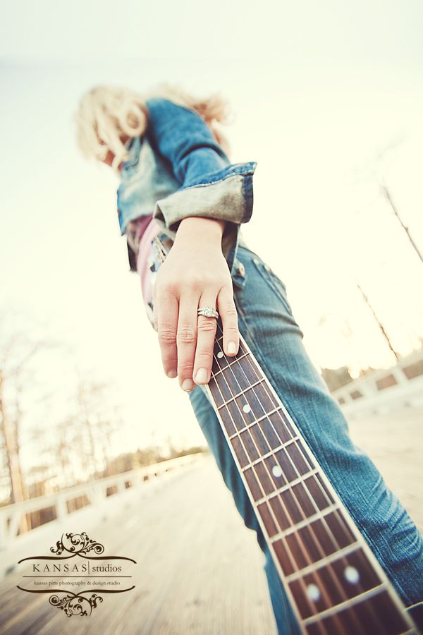 a person holding an electric guitar in their right hand, with the caption's name on it