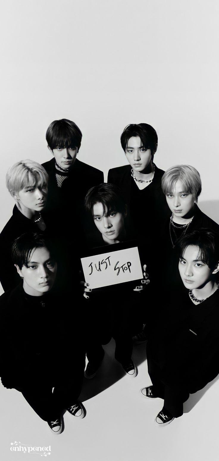 black and white photo of group of young men holding sign that says love in korean