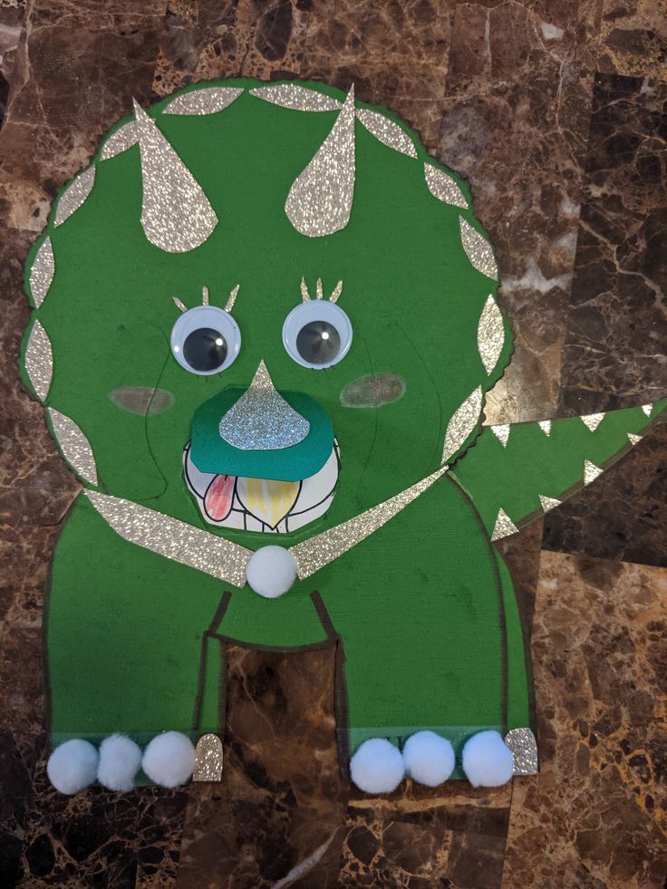 a paper cut out of a green monster with big eyes and horns on it's head