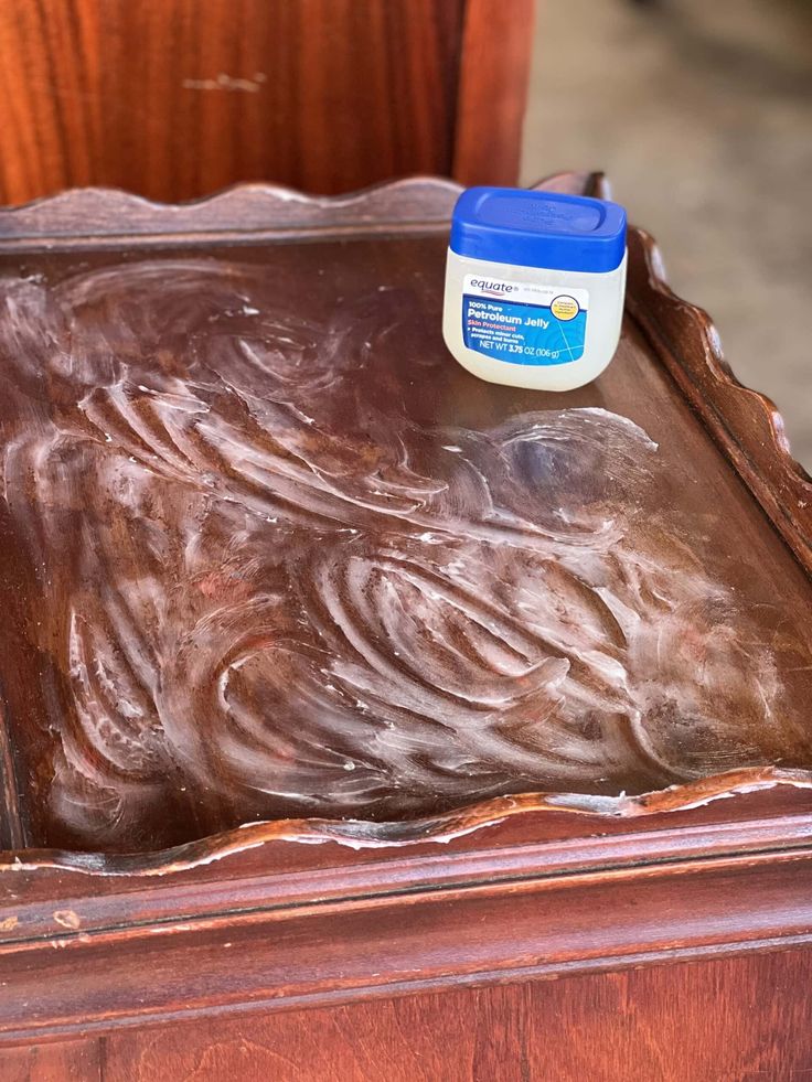 a waxed wooden table with a jar of paint on top