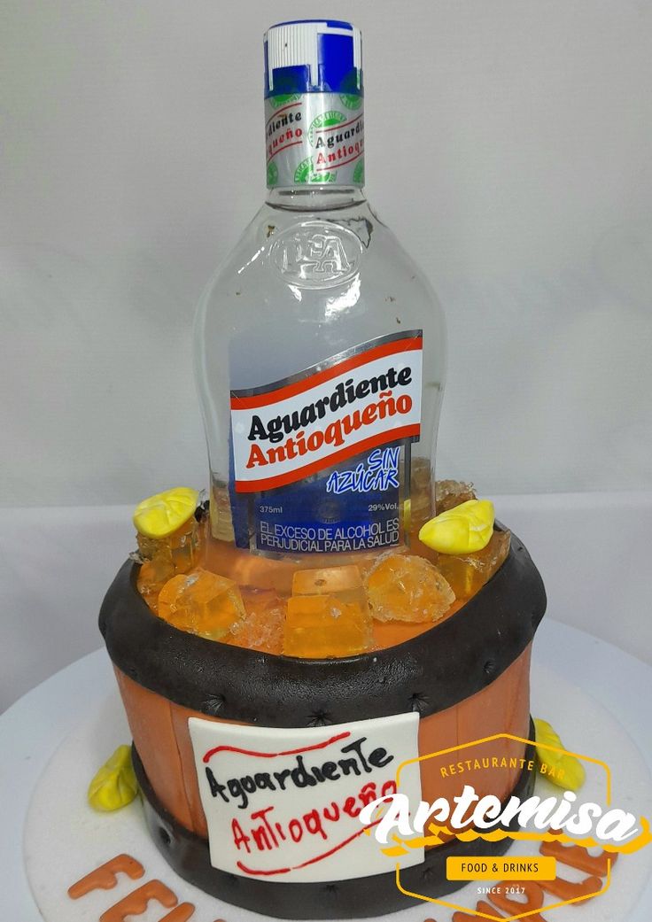 a bottle of alcohol sitting on top of a cake