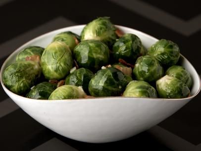 a white bowl filled with brussel sprouts on top of a table