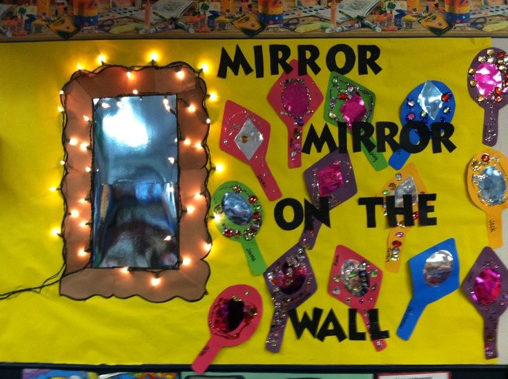 a mirror on the wall is decorated with lights and magnets for kids to use