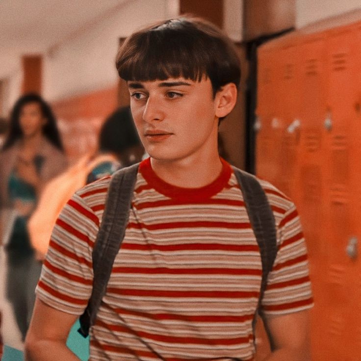 a young man standing in front of lockers