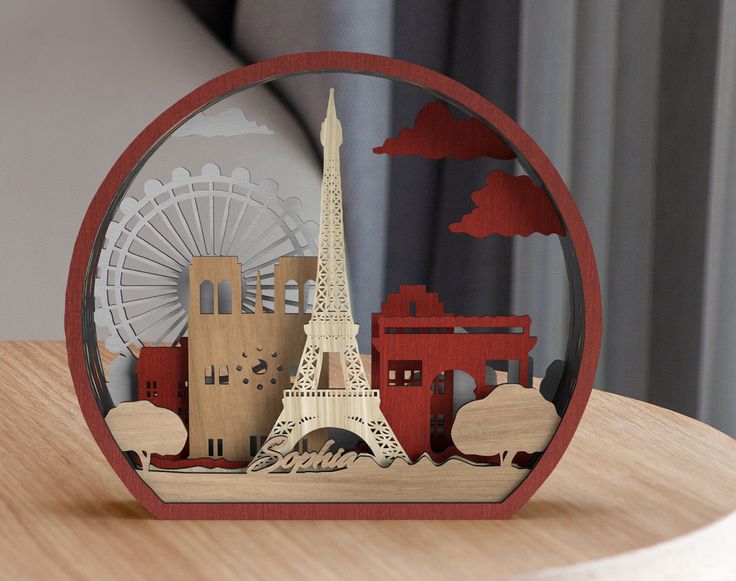 the eiffel tower is cut out of wood and placed on top of a table