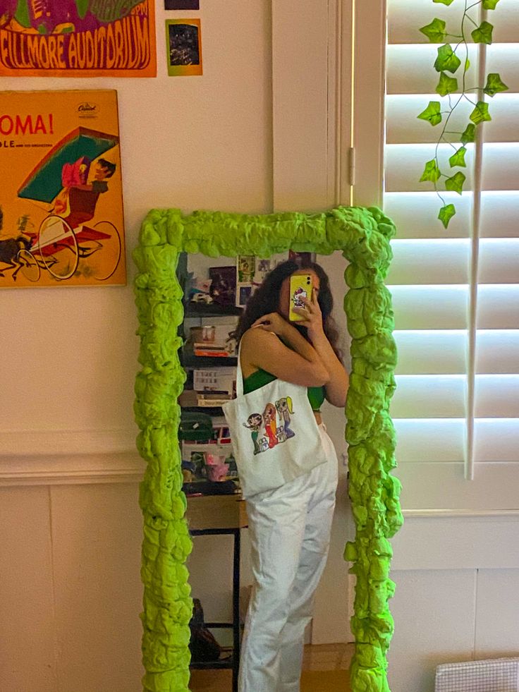 a woman taking a selfie in front of a green frame