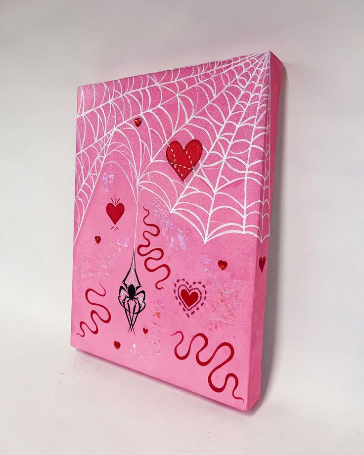 a pink box with spider webs and hearts on it