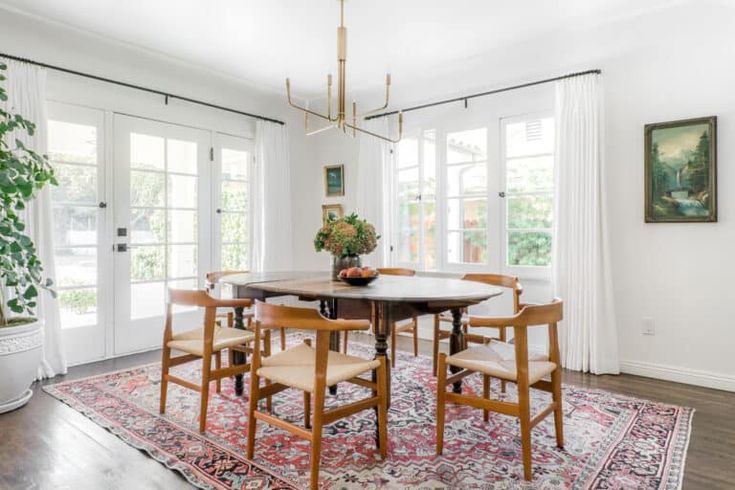 a dining room table with chairs and a rug on the floor in front of it