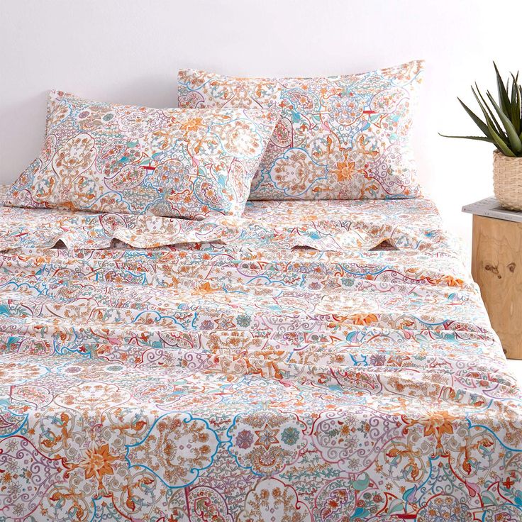 an image of a bedroom setting with bed linens and plants on the side table