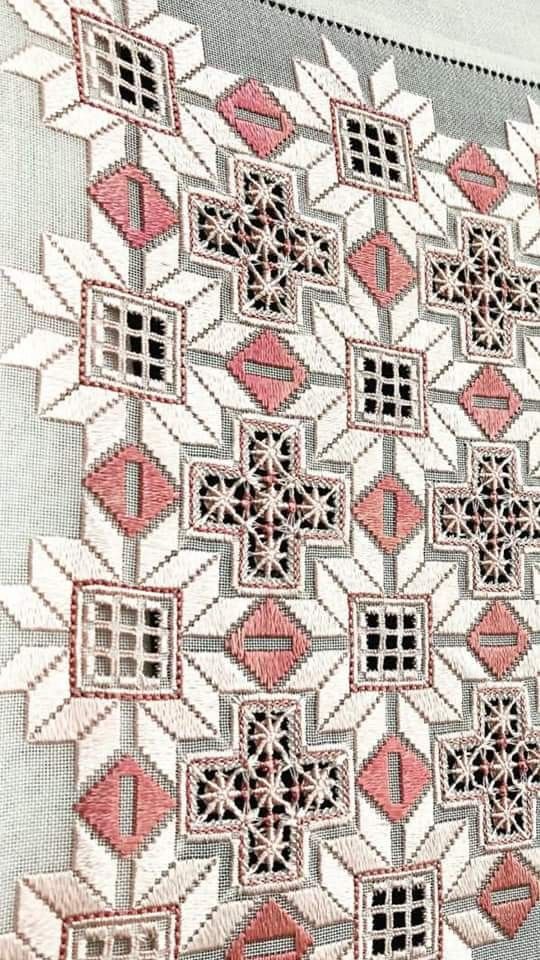 a close up of a piece of cloth with small squares and crosses on the side