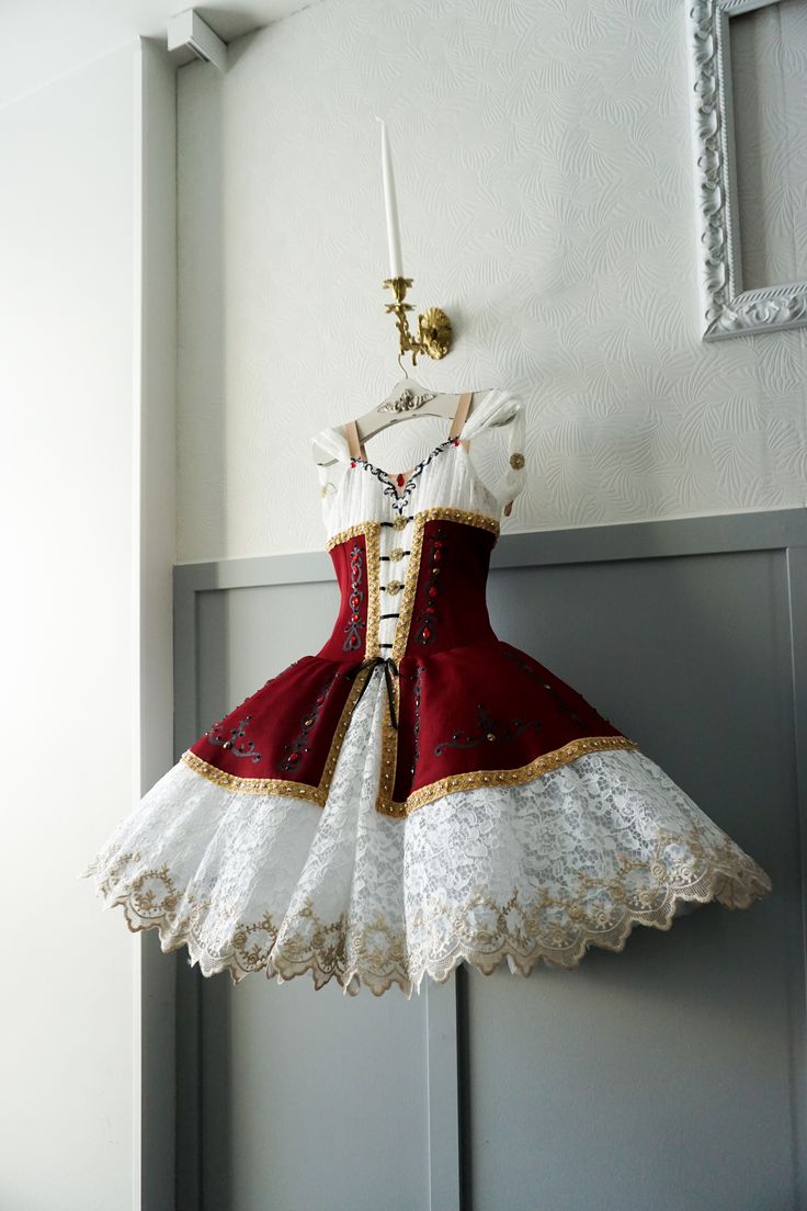 a red and white dress hanging from a hook