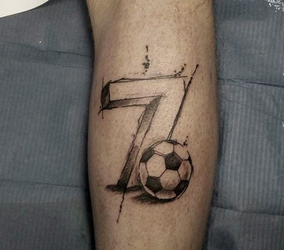 a man's arm with a soccer ball and the number seven tattoo on it