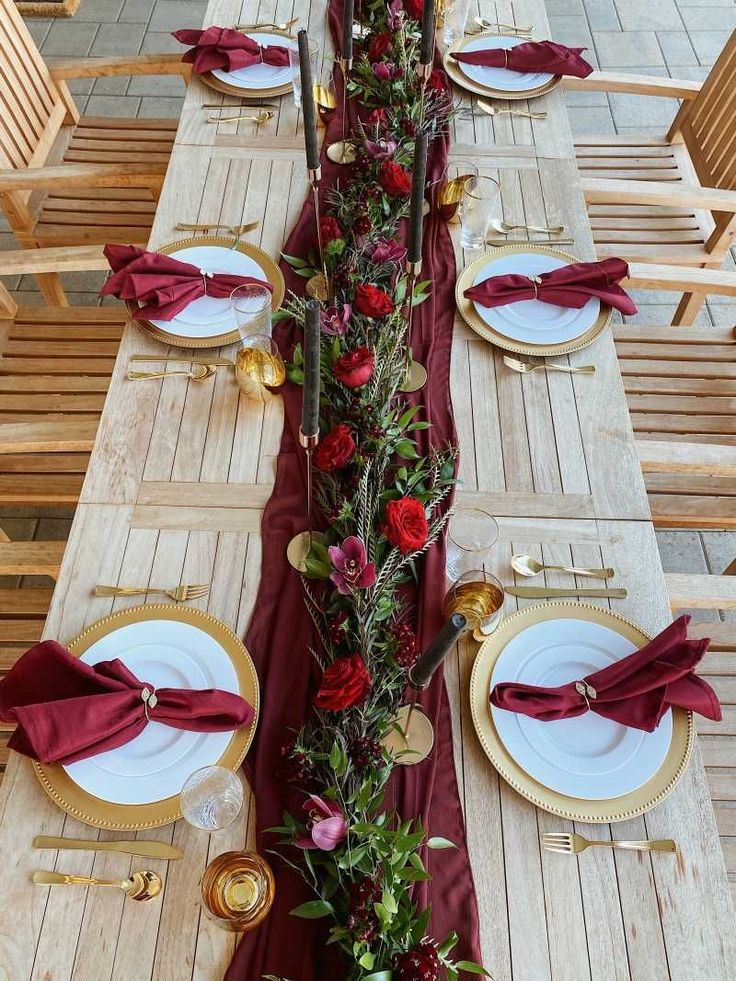 the table is set with red and gold place settings