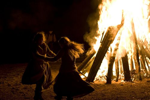 two women dancing in front of a bonfire