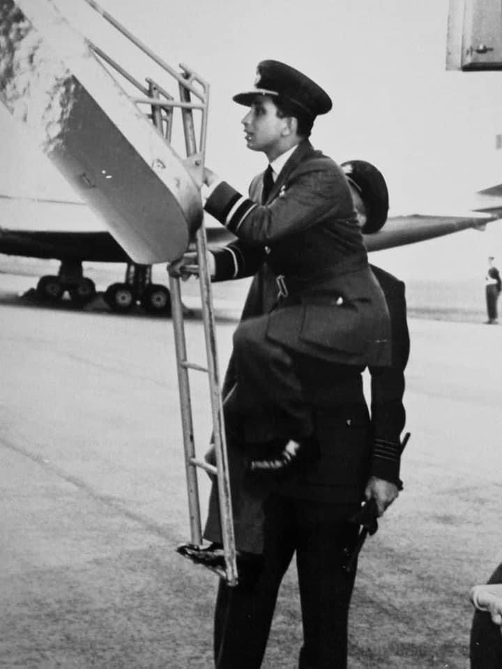 a man in uniform standing next to an airplane