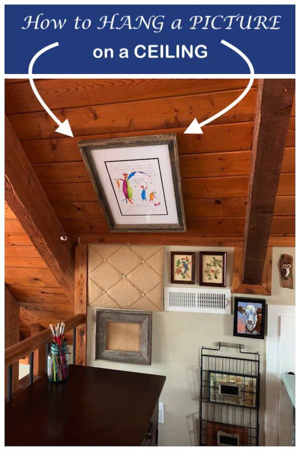 a room with pictures hanging on the wall and an open fireplace in the corner, along with text overlay that reads how to hang a picture on a ceiling