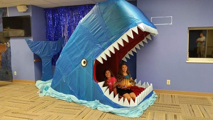 there is a giant shark in the middle of a room with two children inside it