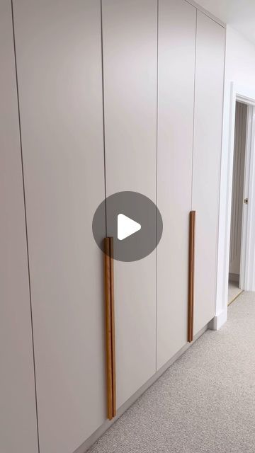 an empty room with white cupboards and wooden handles