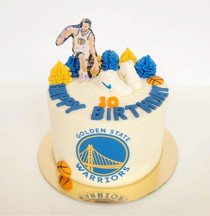 a golden state warriors birthday cake with an image of a basketball player sitting on top