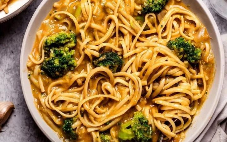 two bowls filled with noodles and broccoli