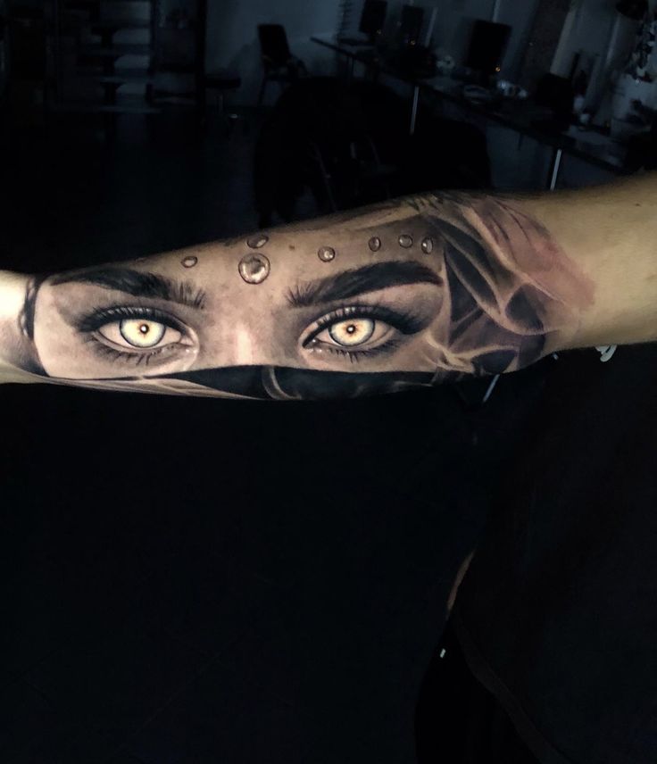 a woman's arm with an eye tattoo on it