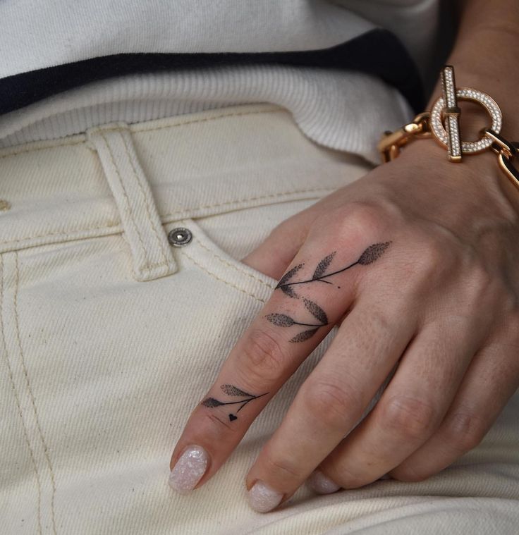 a woman's hand with an arrow tattoo on it