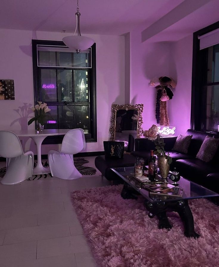 a living room filled with furniture next to a tall window covered in purple lights and decor