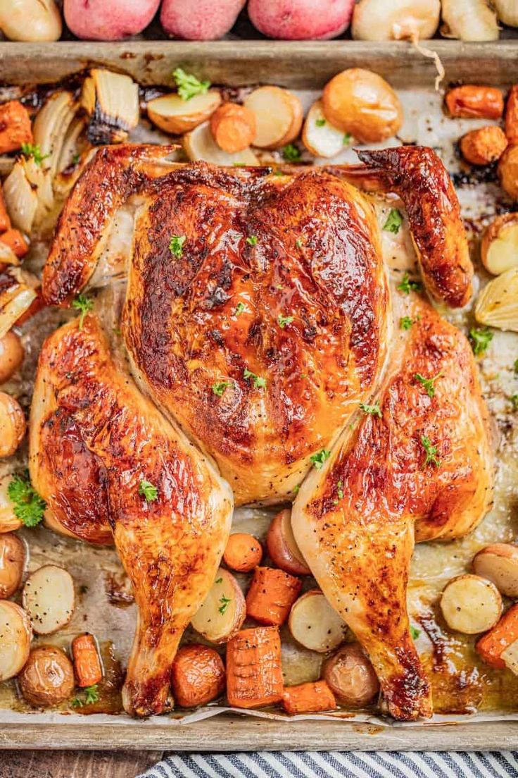 roasted chicken with potatoes and carrots on a baking sheet