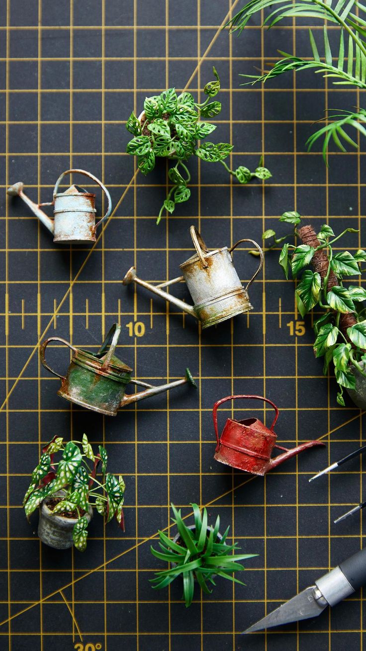 some plants are sitting on top of a cutting board with scissors and other things around them