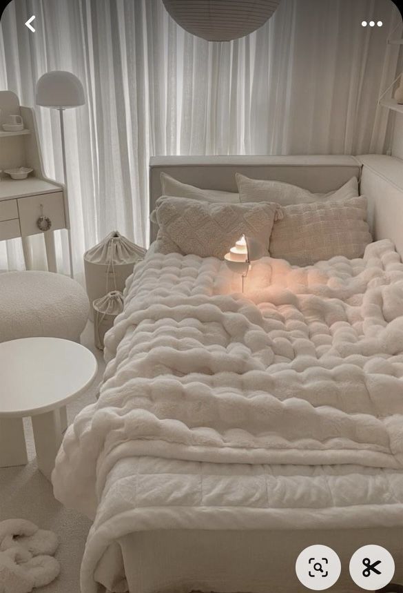 a bed with white sheets and pillows in a room next to a lamp on a table