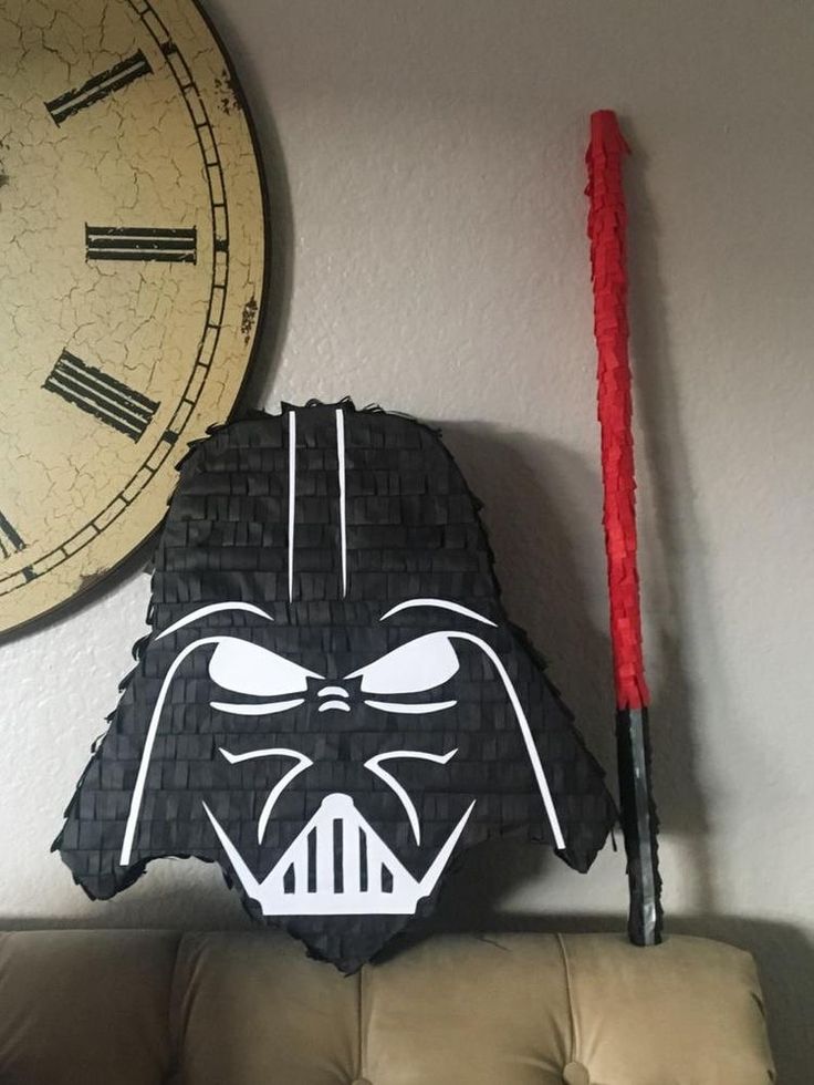 a darth vader mask on the wall next to a clock