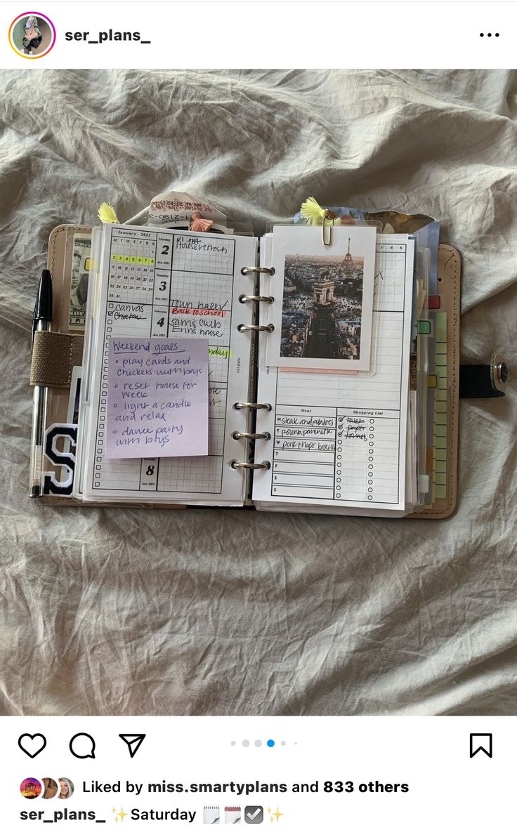 an open planner book sitting on top of a bed