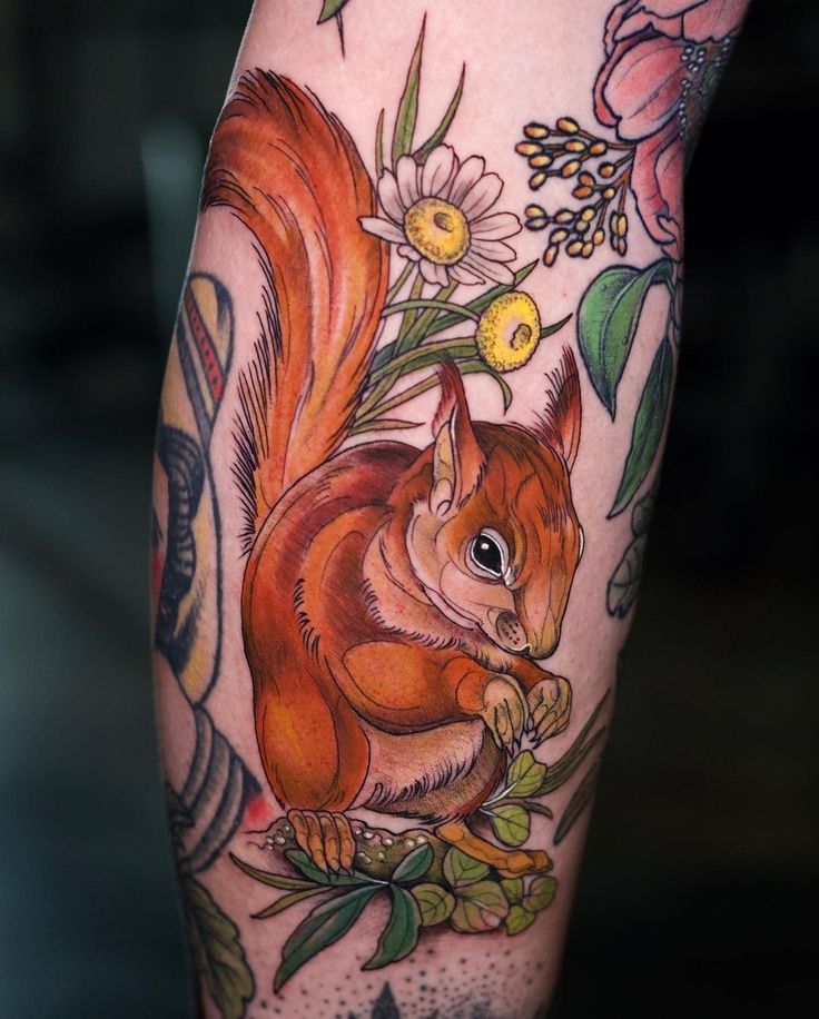 a tattoo with a squirrel and flowers on it