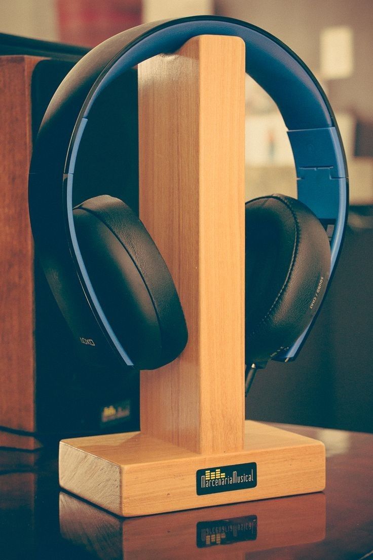 a pair of headphones sitting on top of a wooden stand