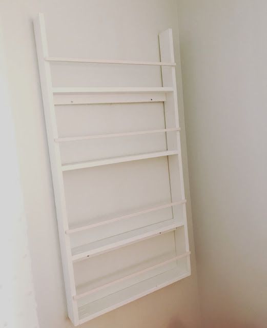 an empty white shelf in the corner of a room