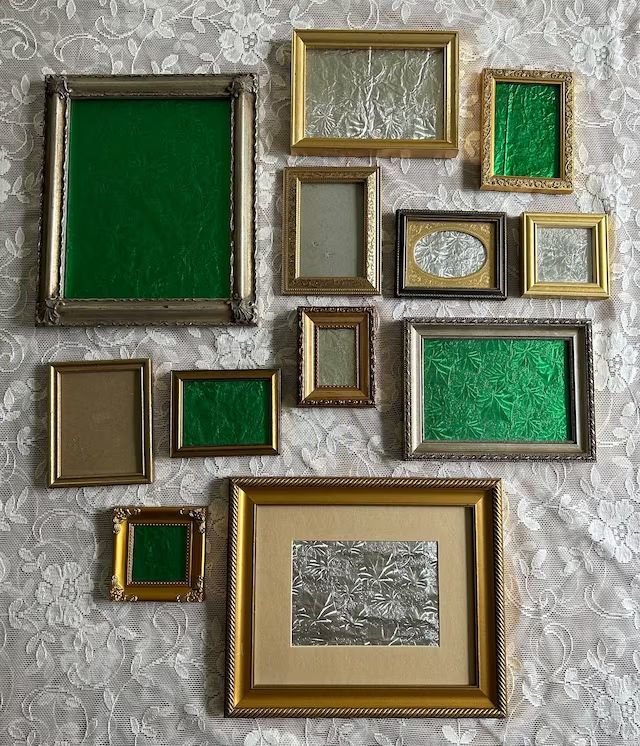 there are many different framed pictures on the wall together, all in gold and green