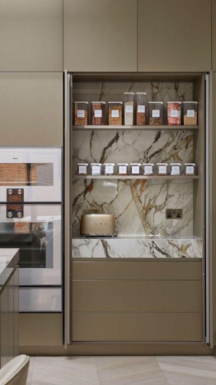 a kitchen with marble counter tops and shelves filled with spices, condiments and other items