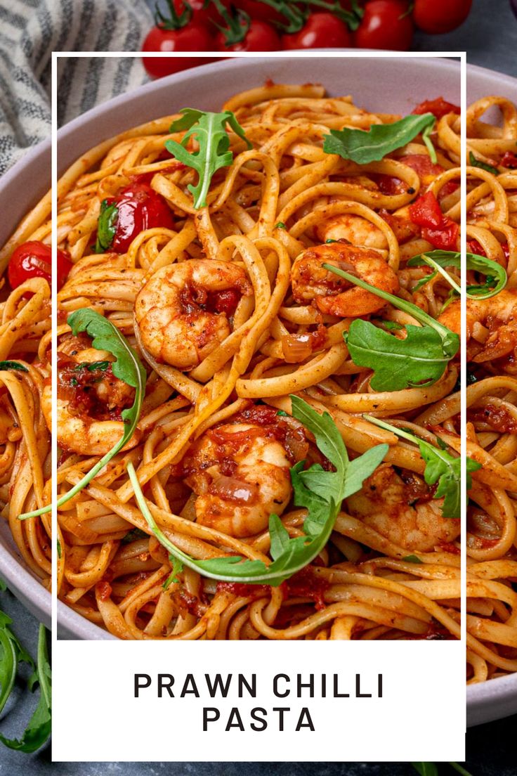 pasta with shrimp and tomato sauce in a white bowl next to fresh basil, cherry tomatoes and parsley