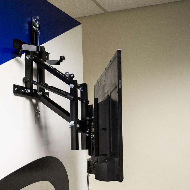 a flat screen tv mounted to the side of a wall next to a blue and white wall