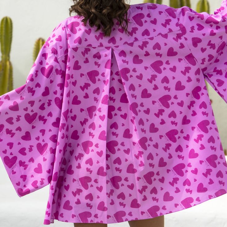 Dive into the fun and flirty vibes of our Agape Kimono cape! This short and sassy kimono is your go-to piece for beach brunch escapades and sunset soirées at your favorite sandy bar. Adorned with our signature JTA hearts print in a playful bubblegum pink, it's the ultimate trendsetter's delight. The perfect cover-up for starfish gazing on the shore, with the Duo Amor Corset and Short or a chilly night enjoying a movie under the stars. Be ready to make waves and turn heads, in the most fabulous way possible! Spring Summer Kimono For Brunch, Summer Style Spring Kimono For Brunch, Summer Printed Kimono For Brunch, Summer Brunch Printed Kimono, Summer Cover-up For Brunch, Pink Spring Cover-up For Beach Party, Spring Beachwear Kimono For Brunch, Spring Beach Long Sleeve Kimono, Spring Beachwear Pink Cover-up