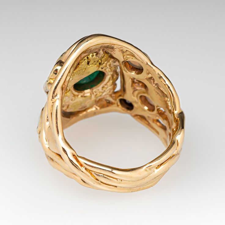 This awesome 14K yellow gold organic, freeform style ring is centered with an 18K yellow gold nugget with a bezel set, round mixed cut emerald, weighing 0.71 carats, in the middle. The shoulders are accented with a total of three (3) round, opal cabochons and two (2) round brilliant cut diamonds in bezel settings. The ring measures 23.8mm at the top, rises 4.7mm above the finger, tapering to 5.5mm wide and 22.1mm thick at the base of the shank. This ring is currently a size 7.5. The emerald shows abrasion and a light scratch/surface reaching natural inclusion. Unique Yellow Gold Oval Emerald Ring, Unique Oval Emerald Ring In Yellow Gold, Unique Gold Emerald Ring With Bezel Setting, Unique Yellow Gold Emerald Ring With Bezel Setting, Unique Gold Emerald Ring Birthstone, Gold Nugget, Round Brilliant Cut Diamond, Round Brilliant Cut, Bezel Setting