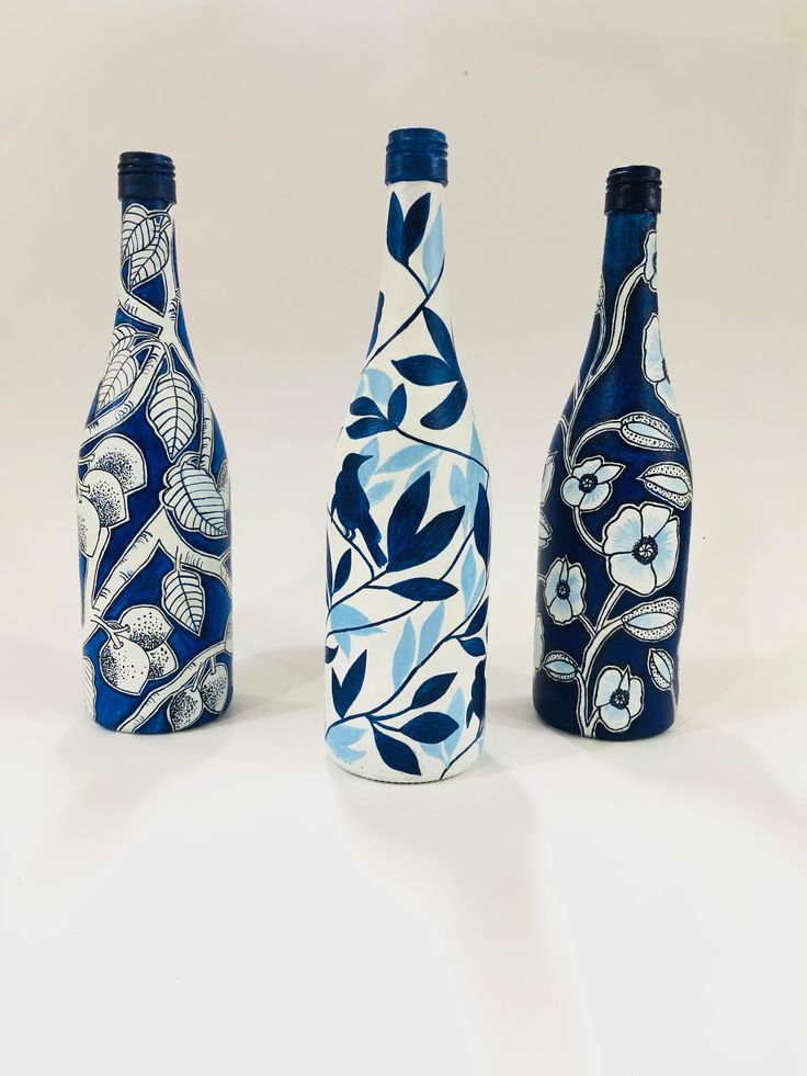 three blue and white vases sitting next to each other on a white table top