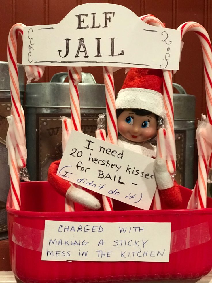 an elf is sitting in a bucket with candy canes and a sign that says i need hershey kisses for ball